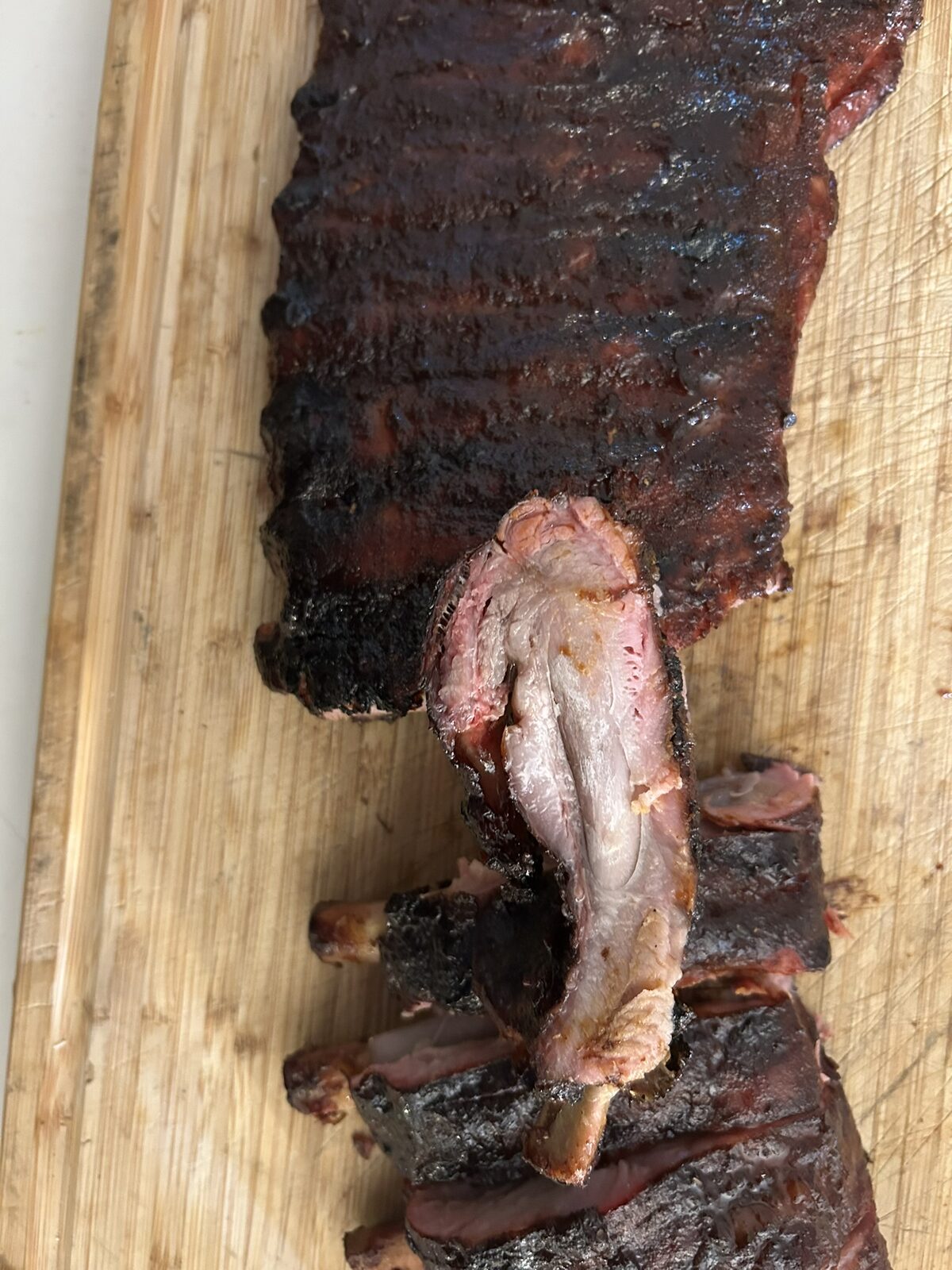 Smoked St. Louis ribs being pulled apart showing the texture