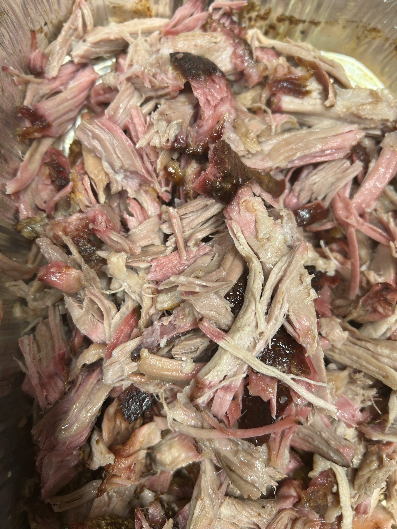 Finished pulled pork shoulder shredded into tender pieces